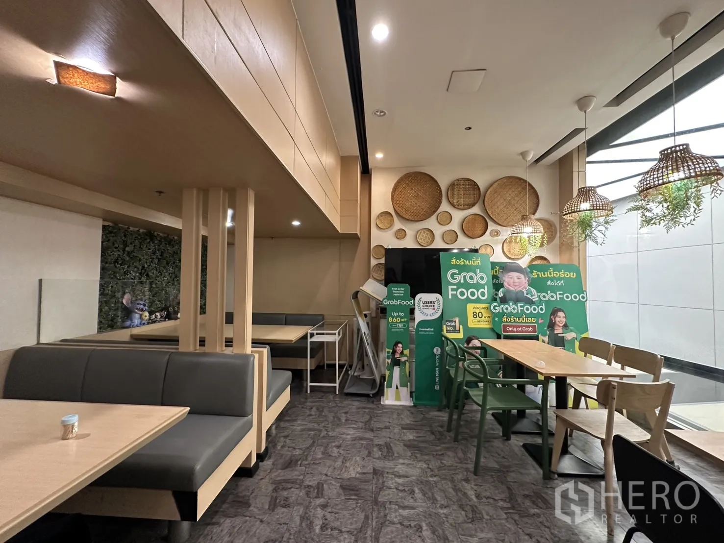 零售空间 for rent in Watthana, Bangkok - 就餐区配有卡座、木质餐桌和藤编吊灯。
