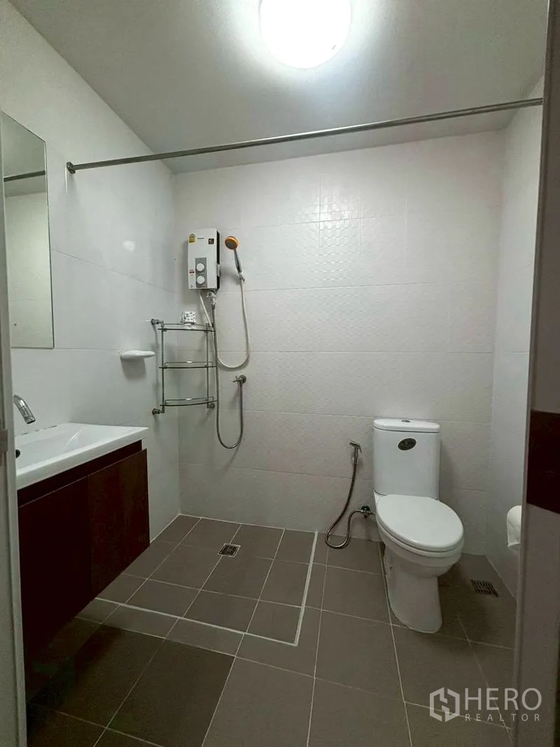 Townhouse for rent in Suan Luang, Bangkok - Spacious bathroom with shower water heater, toilet, and sink.