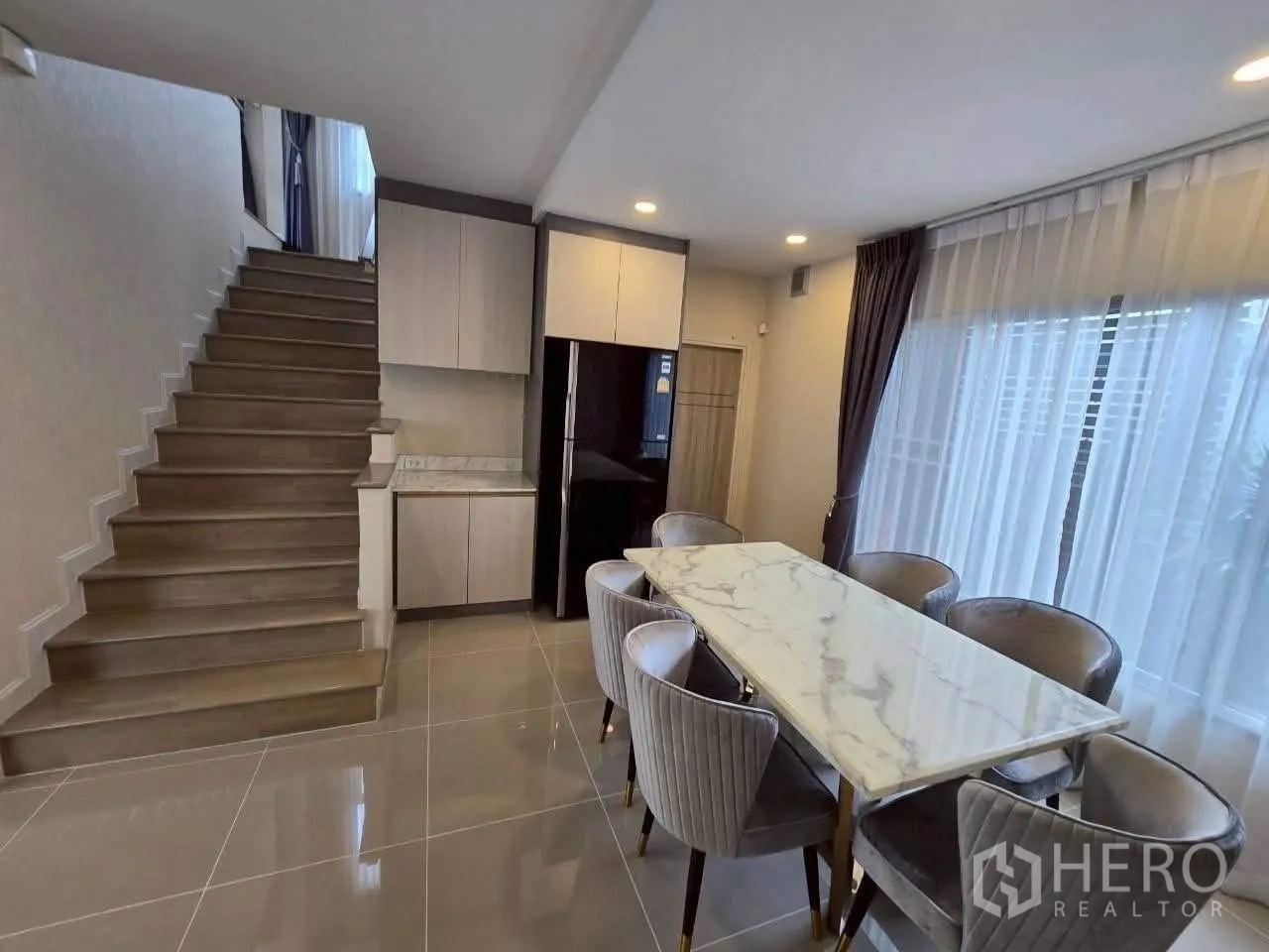 独栋房屋 for rent or sale in Lat Krabang, Bangkok - 餐区靠近楼梯，配大理石餐桌与六把软包餐椅。