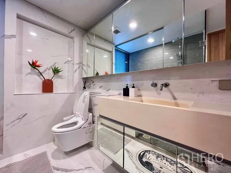 Condominium for rent - Modern bathroom with marble-style walls, long vanity and smart toilet.