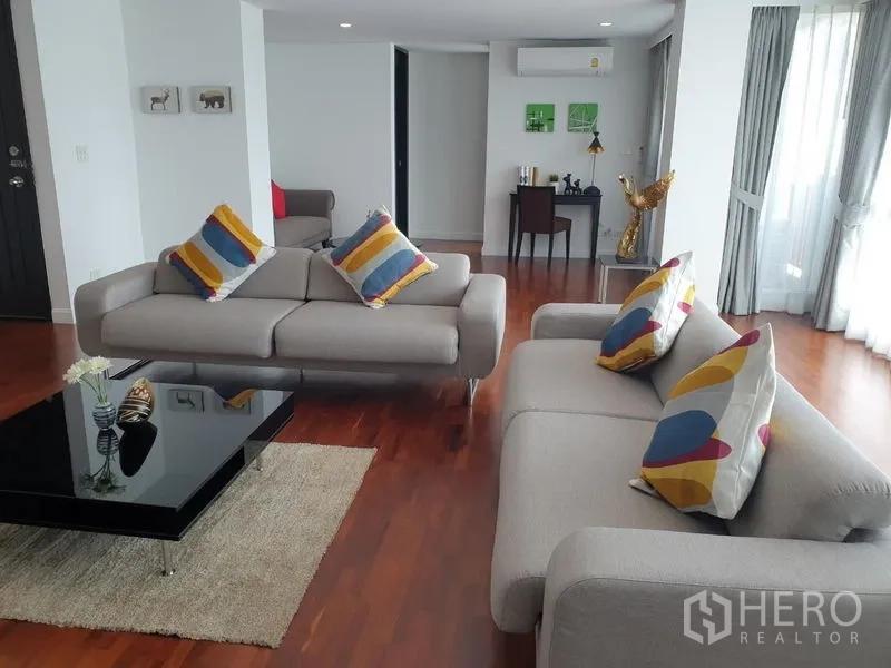 公寓 出租在Bang Rak, Bangkok - 舒适起居区，灰色沙发、彩色抱枕与茶几