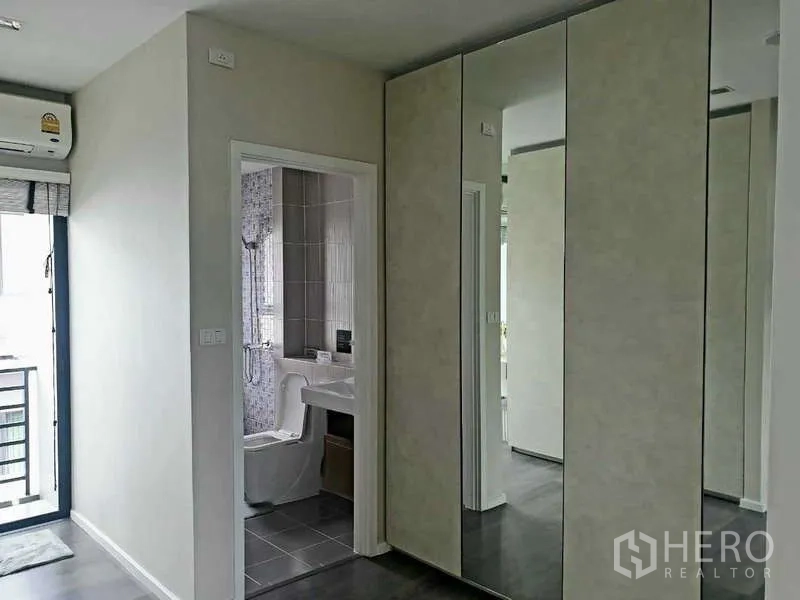 Home Office for rent in Bang Phli, Samut Prakan - Hallway with mirrored wardrobes leading to a modern tiled bathroom.