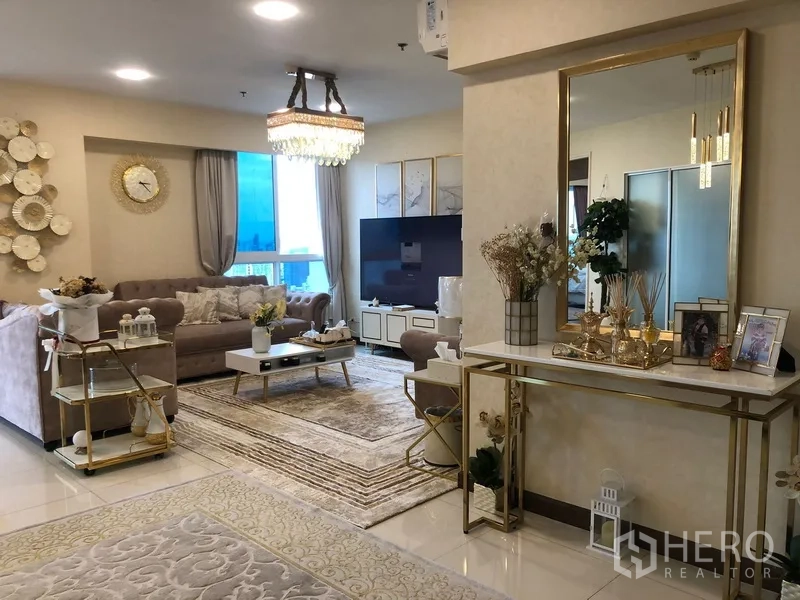 公寓 出售在Yan Nawa, Bangkok - 时尚客厅，水晶吊灯、柔软沙发、大屏电视与金色装饰镜。