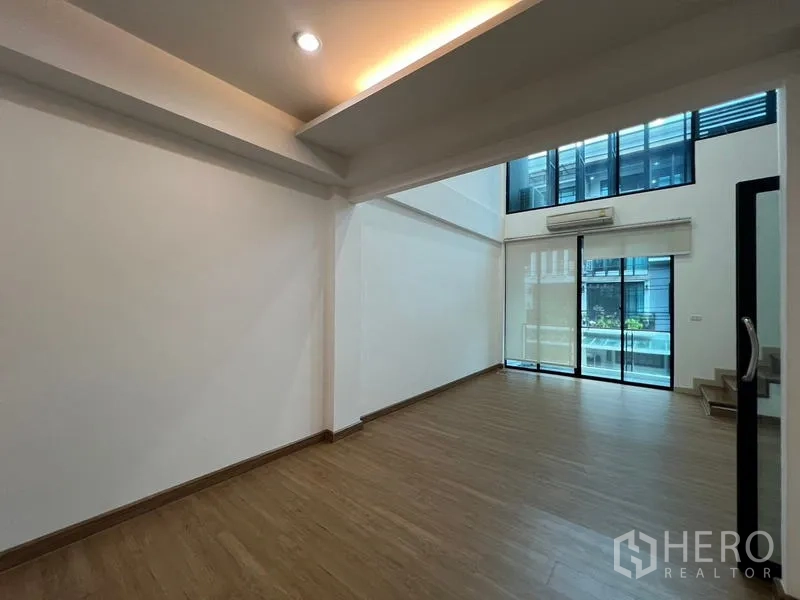 联排别墅 出租或出售在Khlong Toei, Bangkok - 挑高客厅，大面积落地窗并连接阳台。