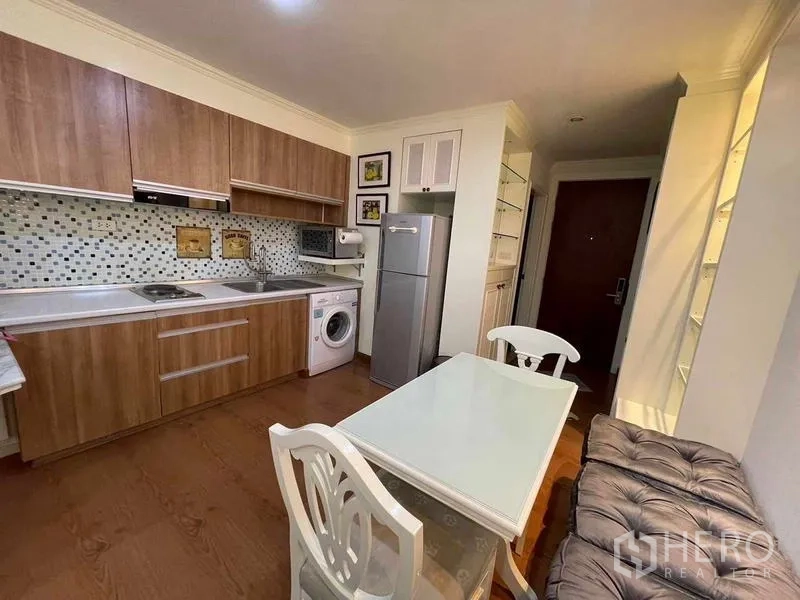 Condominium for rent - Full kitchen with wooden cabinets, mosaic backsplash, fridge and washing machine.
