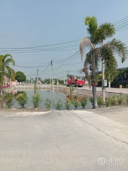 Factory for rent in Lat Lum Kaeo, Pathum Thani - Canal-side frontage with roadside access, utilities and a passing truck in front of the estate.