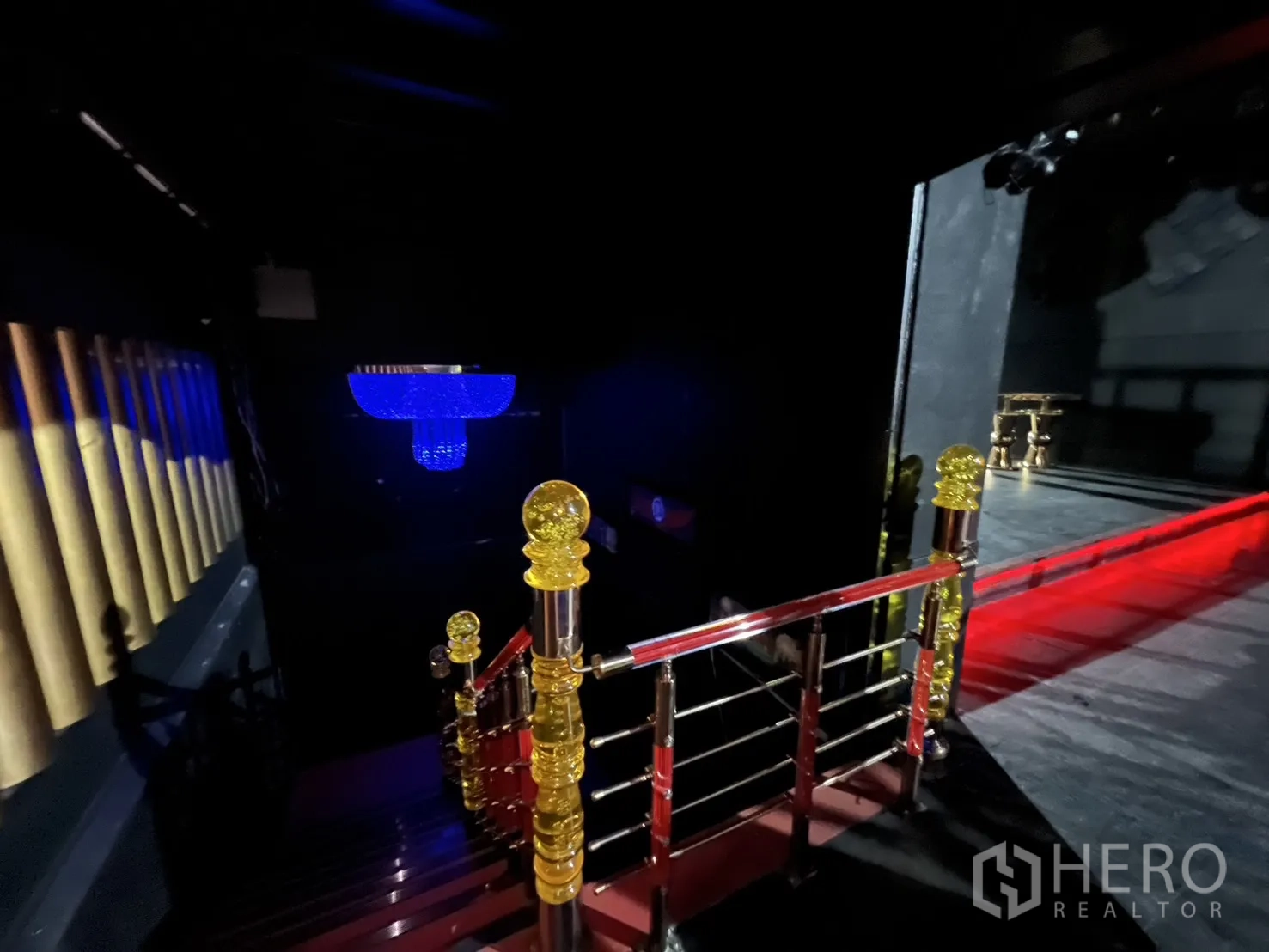 Retail Space for rent - Staircase with red steps and gold finials leading to the upper level and chandelier.