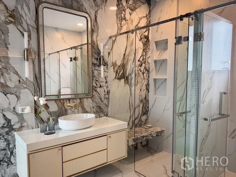 Detached House for rent or sale - Luxury bathroom with marble walls, a glass shower, and a modern vanity.