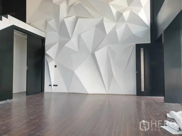 Retail Space for rent in Khlong Toei, Bangkok - Close view of 3D geometric wall panels and a black sliding door within the showroom area.