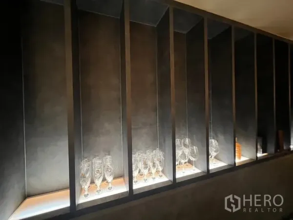 Retail Space for rent in Bang Rak, Bangkok - Backlit display niches showcasing glassware along a dark feature wall.
