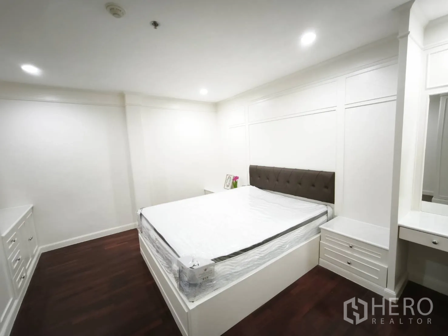 คอนโด for rent in Watthana, Bangkok - ห้องนอนที่สองพร้อมเตียง โต๊ะข้าง เตียง และตู้บิลท์อินสีขาว พื้นไม้สีเข้ม