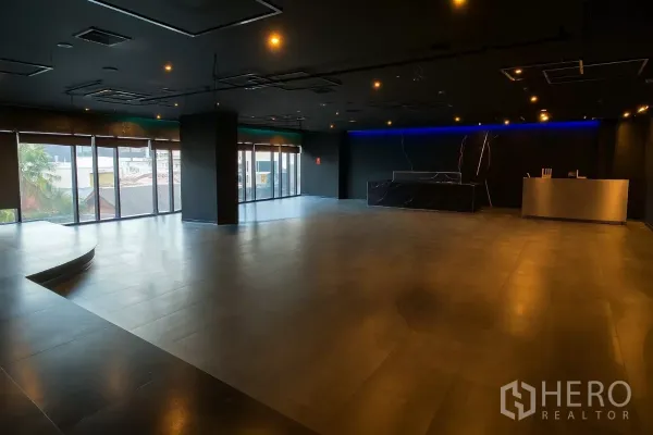 Retail Space for rent - Corner retail space with curved platform, ceiling spotlights and city views through tall windows.