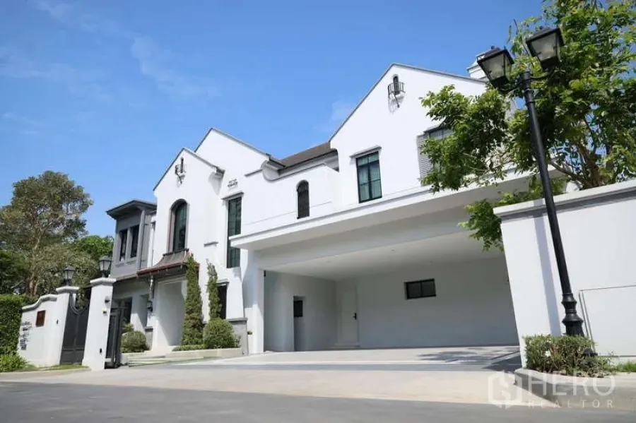 Detached House for rent or sale in Saphan Sung, Bangkok - Grand front elevation with wide covered carport and manicured trees.