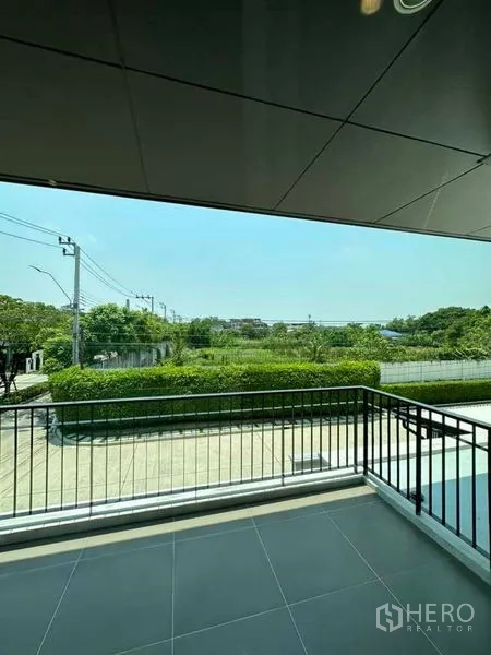 独立式住宅 出售在Prawet, Bangkok - 二楼阳台俯瞰绿地与社区道路。
