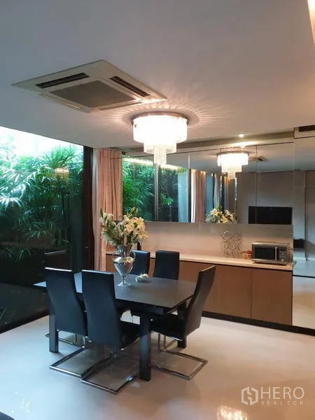 独立式住宅 出售在Watthana, Bangkok - 餐厅配水晶吊灯与镜面墙，可眺望绿意庭院。
