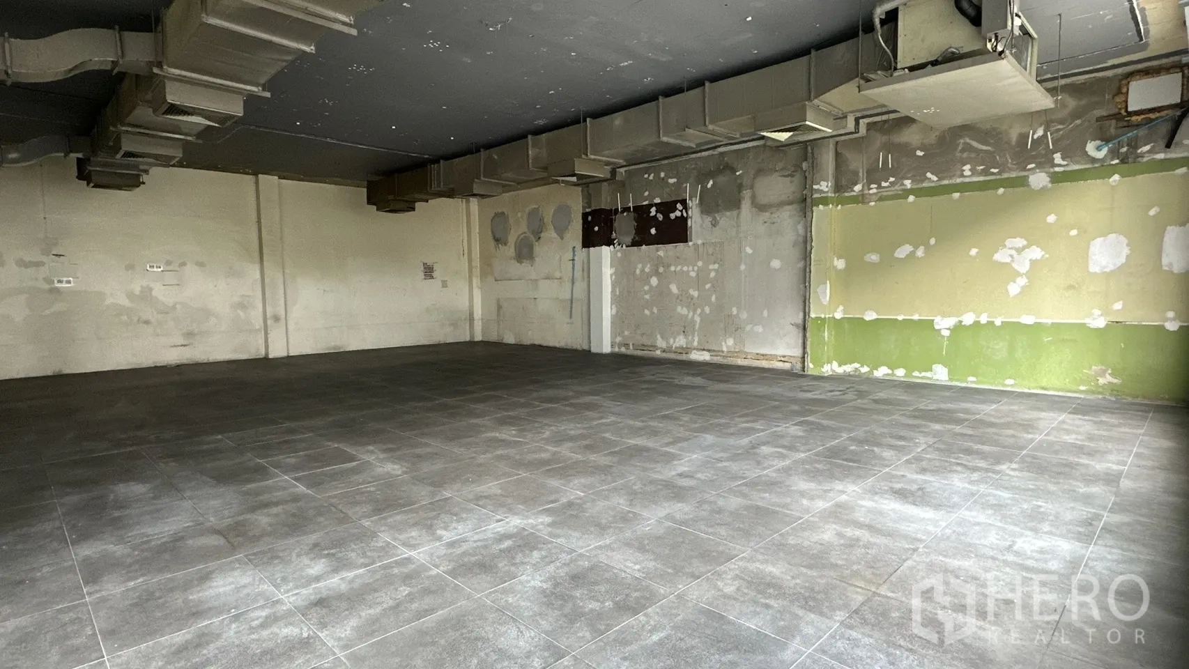 พื้นที่ขายของ for rent in Watthana, Bangkok - มุมห้องผนังยังไม่ตกแต่ง พื้นกระเบื้องสีเทา.
