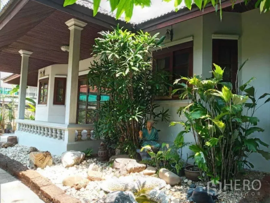 บ้าน ให้เช่าในKhlong Toei, Bangkok - มุมมองภายนอกบ้านล้อมรอบด้วยต้นไม้สีเขียวและงานจัดสวนหิน