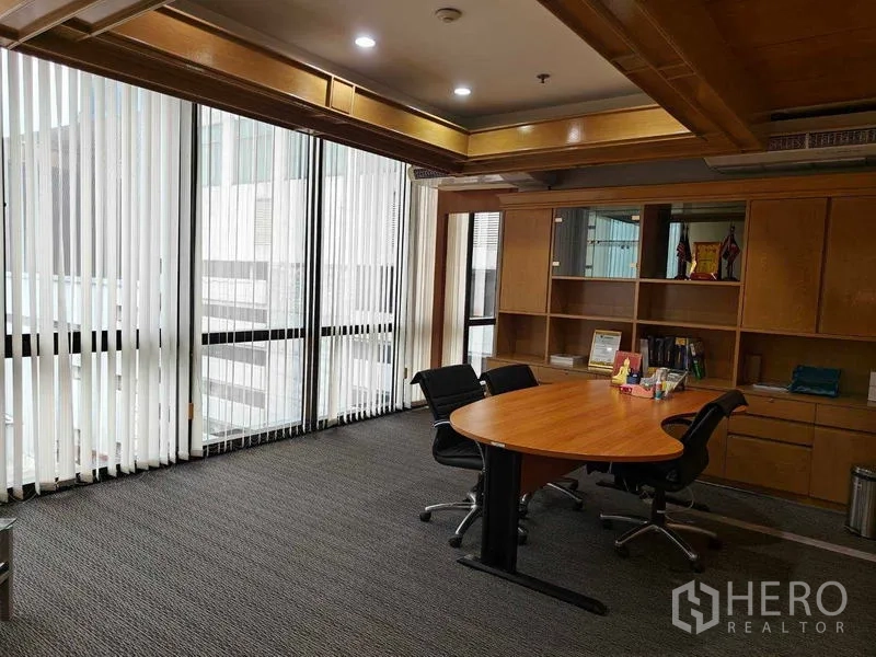 Office Space for rent in Din Daeng, Bangkok - Executive meeting room with round table, built-in shelves, and full-height windows with blinds.