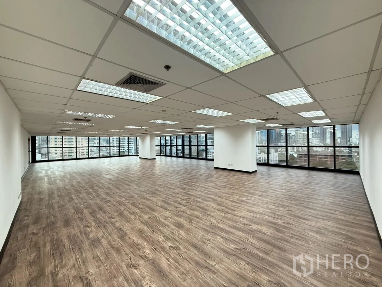 Office Space for rent in Watthana, Bangkok - Large empty office floor with expansive windows and uniform lighting over the city.