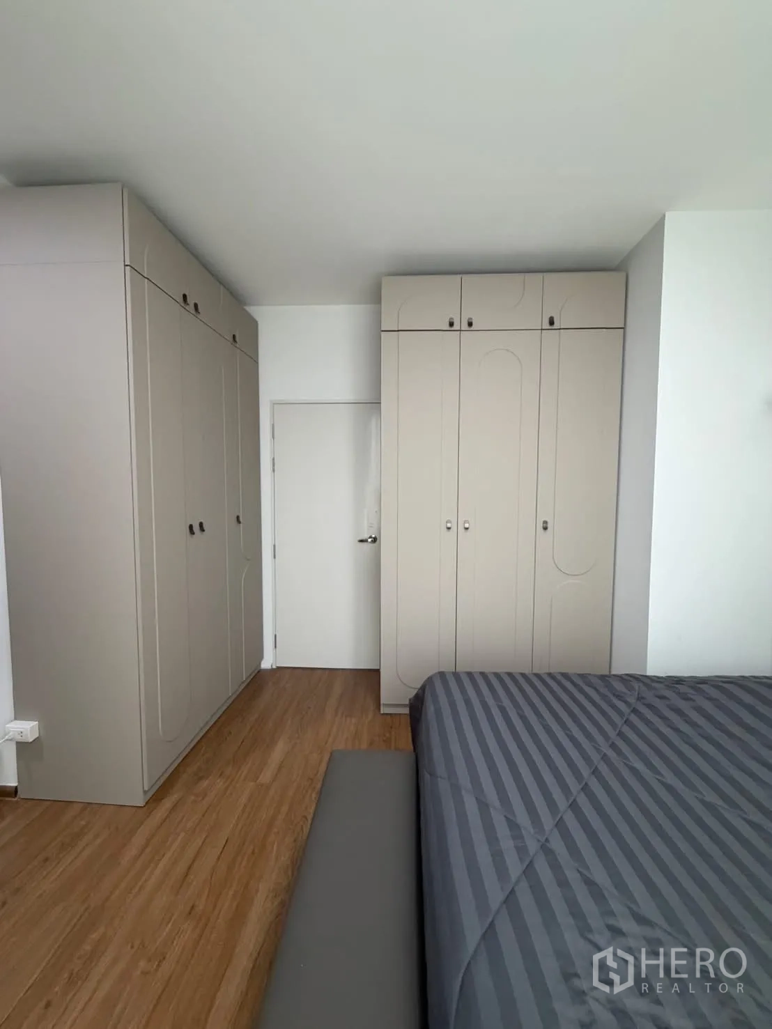联排别墅 for rent in Bang Phli, Samut Prakan - 卧室设米色嵌入式衣柜与木地板，部分双人床可见。