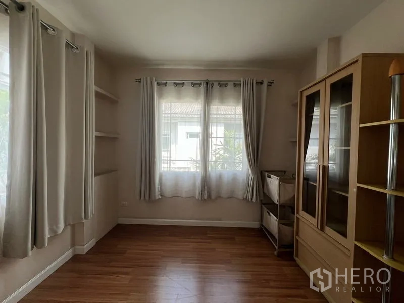 Detached House for rent in Bang Kapi, Bangkok - Empty corner room with curtains, wall shelves and display cabinet.