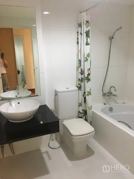 公寓 出租或出售在Watthana, Bangkok - 明亮浴室，浴缸、手持花洒、台上盆与白色瓷砖。