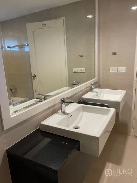 Detached House for rent in Bang Phli, Samut Prakan - Modern bathroom with double square basins, a large mirror, and beige tiled walls.