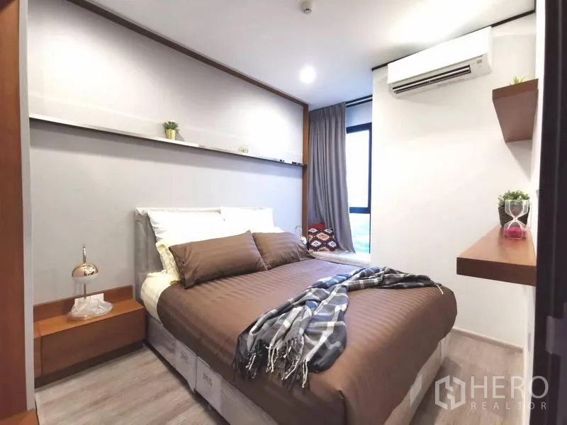 คอนโด ให้เช่าในHuai Khwang, Bangkok - ห้องนอนที่สองขนาดกะทัดรัด มีเครื่องปรับอากาศ ชั้นลอย และชุดเครื่องนอนสีน้ำตาล