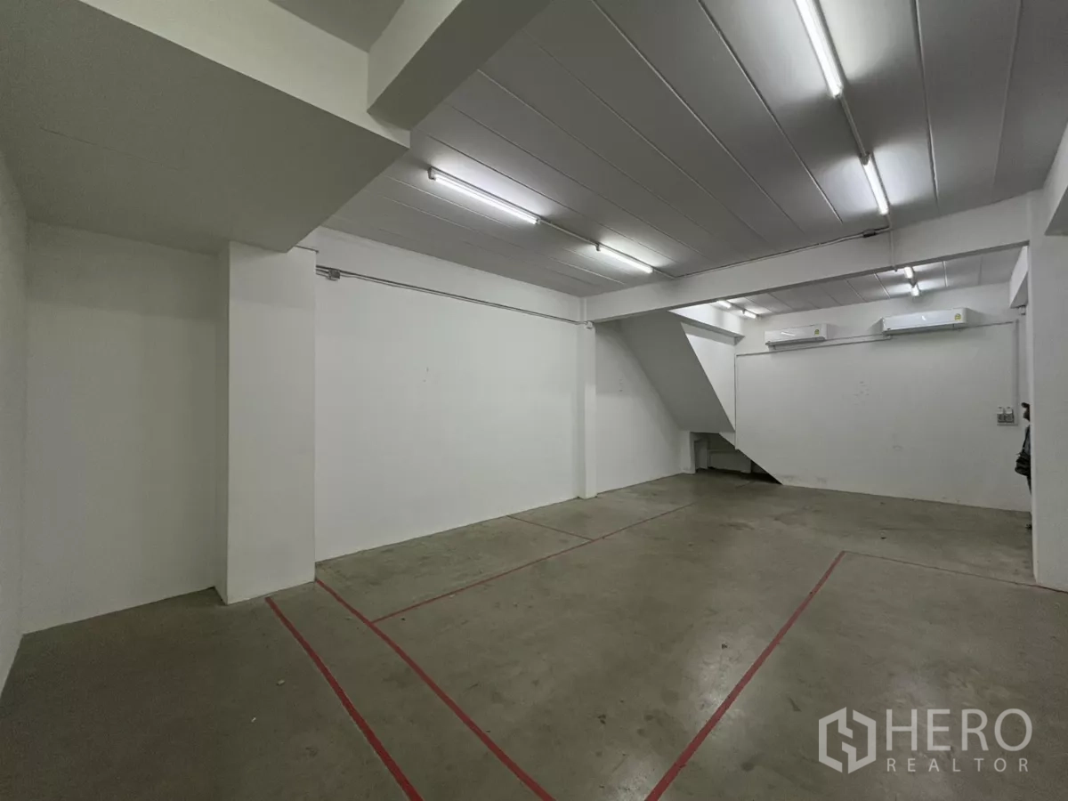 Factory for rent in Phra Samut Chedi, Samut Prakan - Open workspace with stairs and two wall-mounted air conditioners.