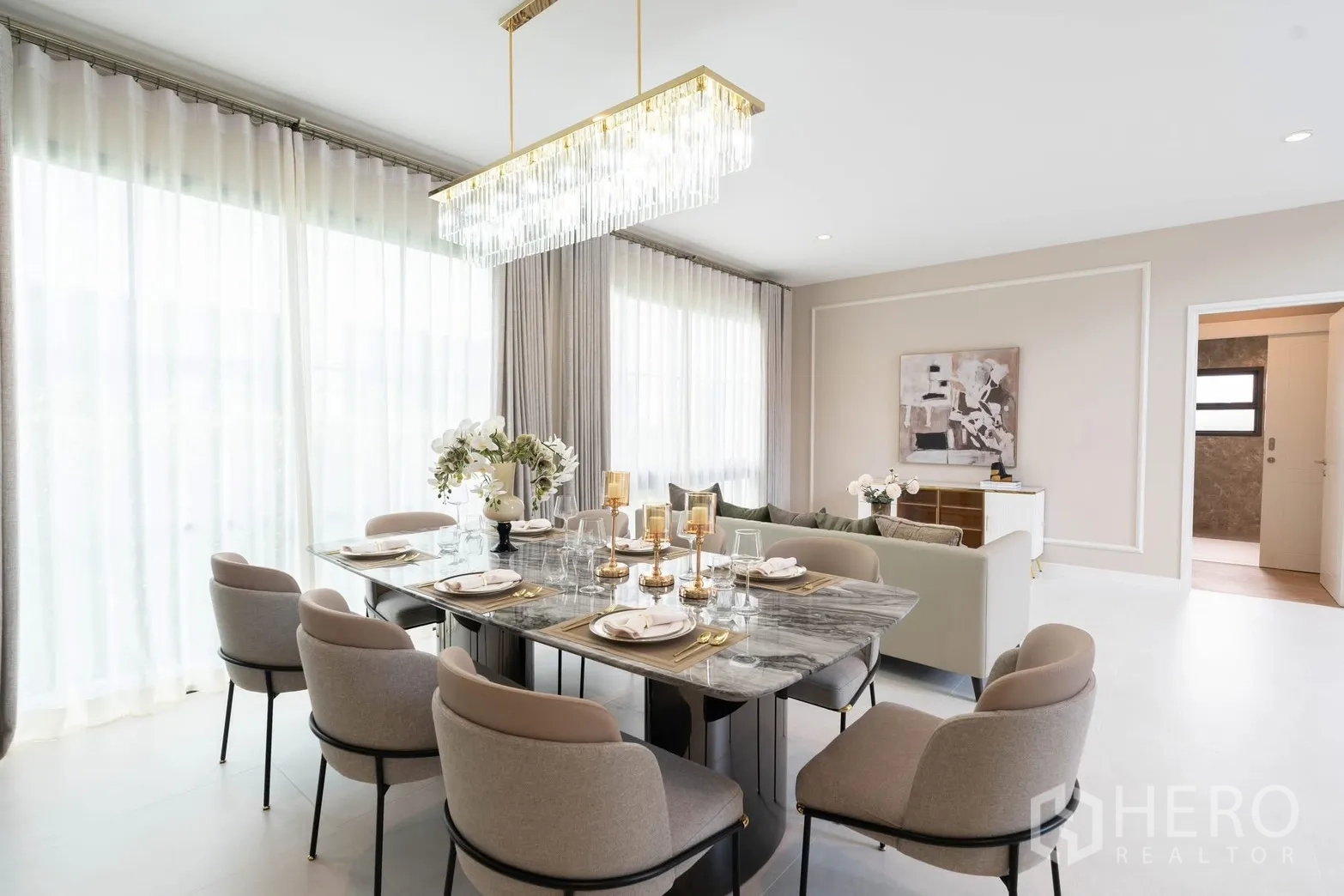 Detached House for rent in Bang Phli, Samut Prakan - Dining area with marble table, eight upholstered chairs, and crystal chandelier.