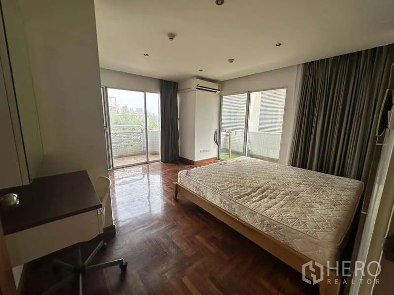 公寓 出租在Watthana, Bangkok - 主卧配大窗户，双阳台门与书桌。