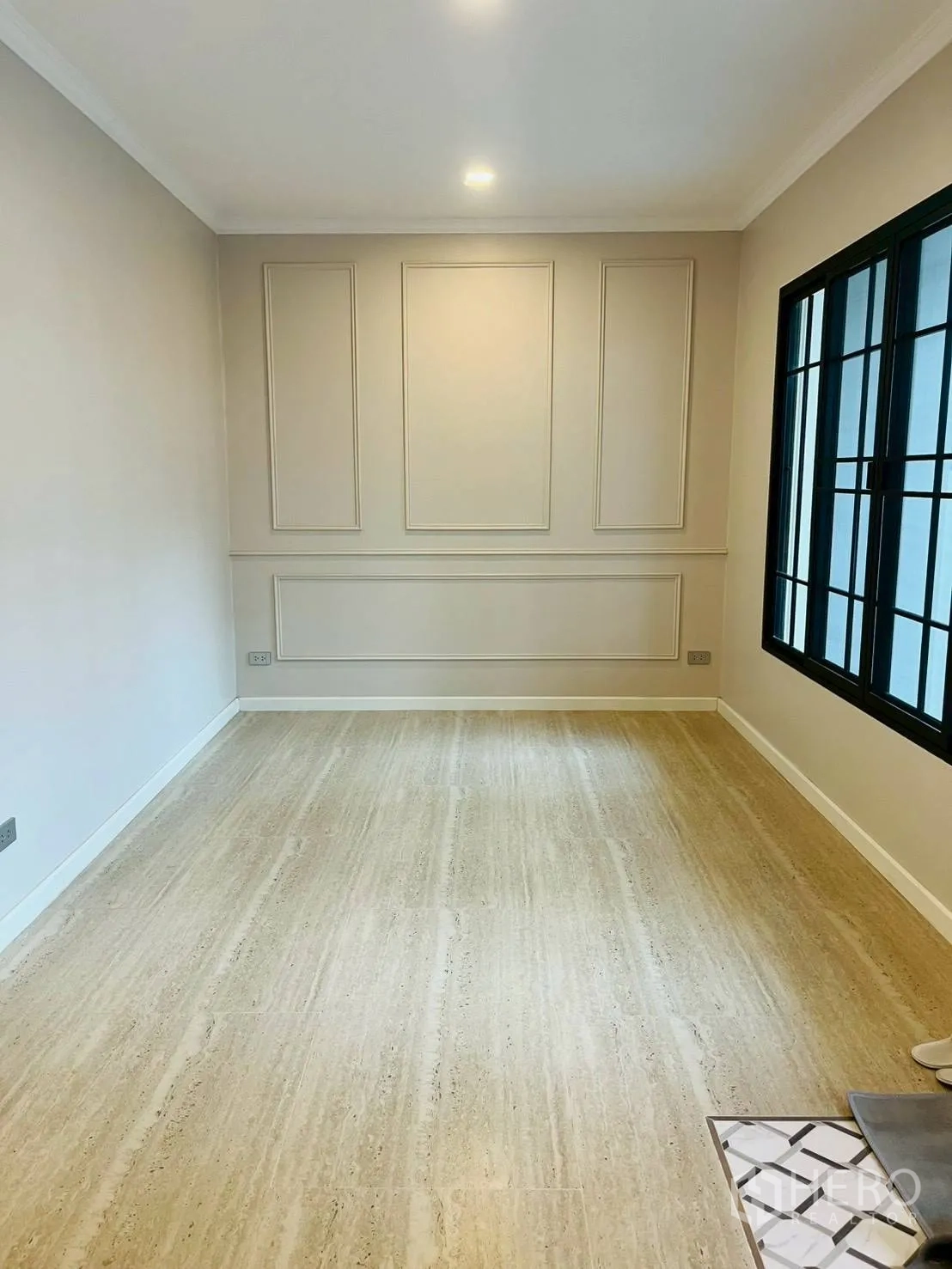 联排别墅 for rent in Khlong Toei, Bangkok - 明亮房间，带造型墙面、大幅黑框窗与木纹地面。