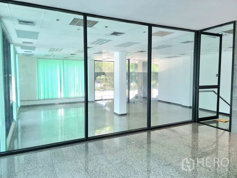 零售空间 出租在Sathon, Bangkok - 透过室内玻璃隔断可见宽敞零售区域，地面光洁、采光良好。