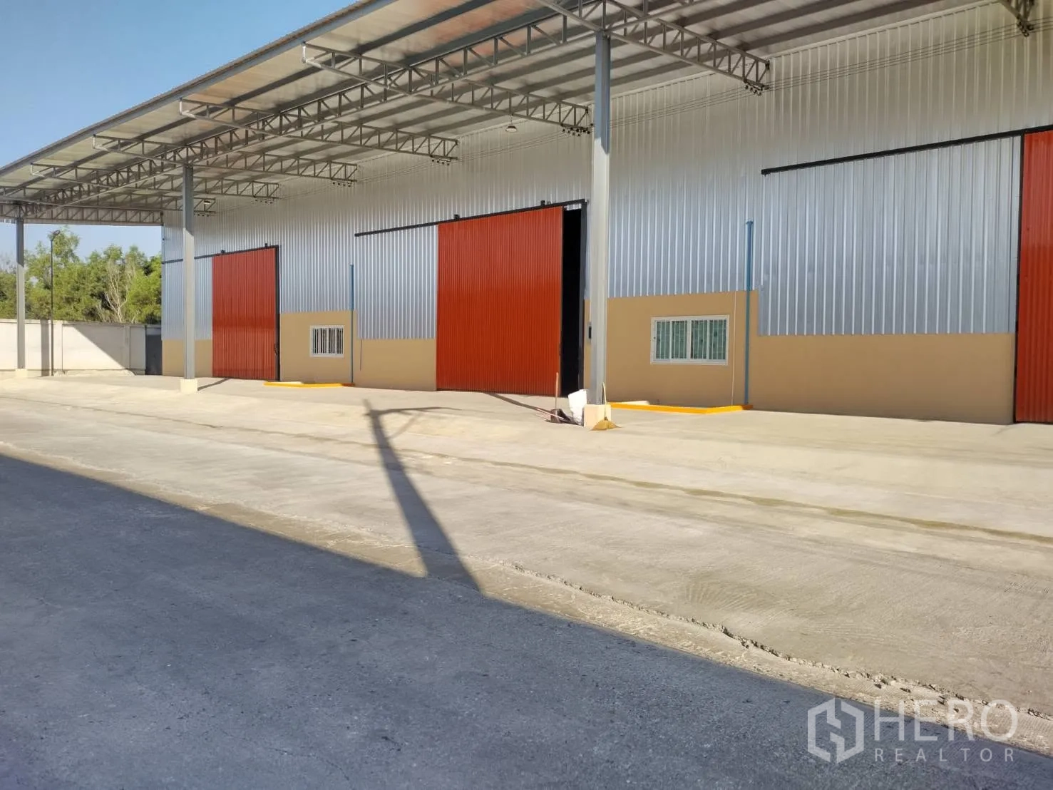 仓库 for rent in Khlong Luang, Pathum Thani - 仓库立面，开启的推拉门、钢柱结构与深混凝土装卸区