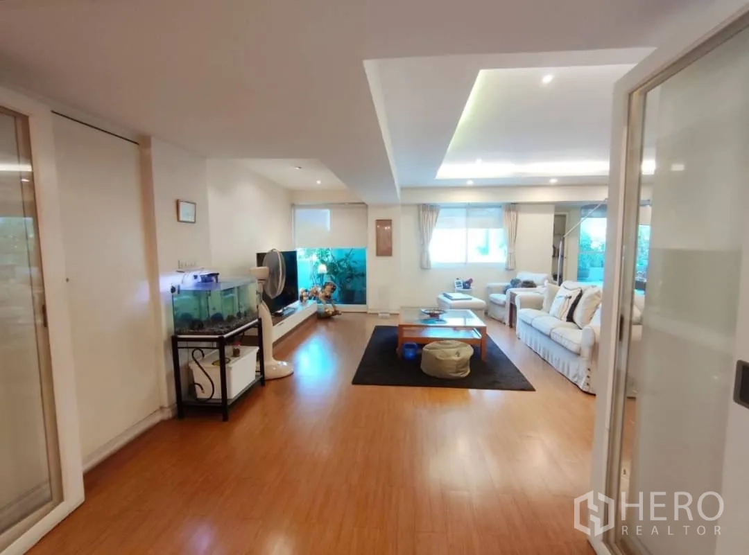 คอนโด ให้เช่าในWatthana, Bangkok - ห้องนั่งเล่นพร้อมชั้นวางทีวี ตู้ปลา และโซฟาสีขาว
