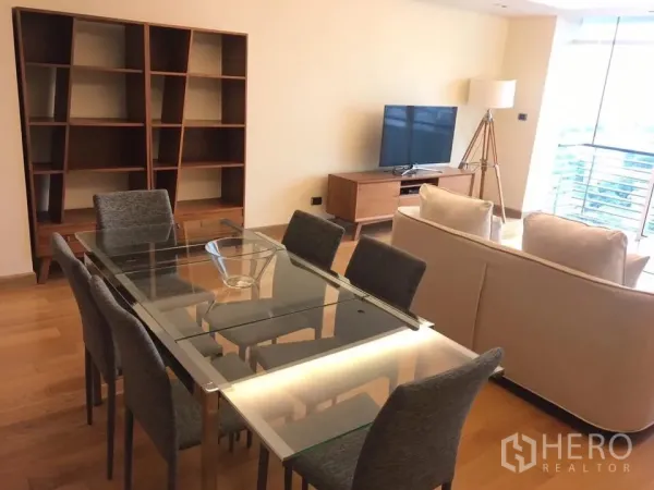 Condominium for rent in Phaya Thai, Bangkok - Glass-top dining table for six beside sofa seating and large windows with city view.