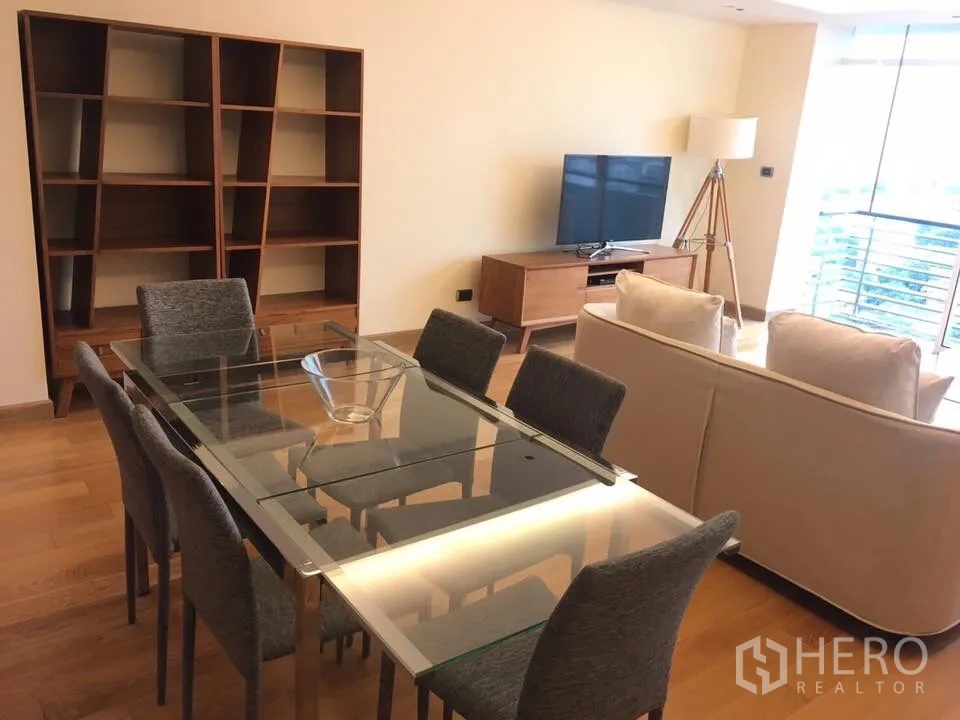 Condominium for rent in Phaya Thai, Bangkok - Glass-top dining table for six beside sofa seating and large windows with city view.