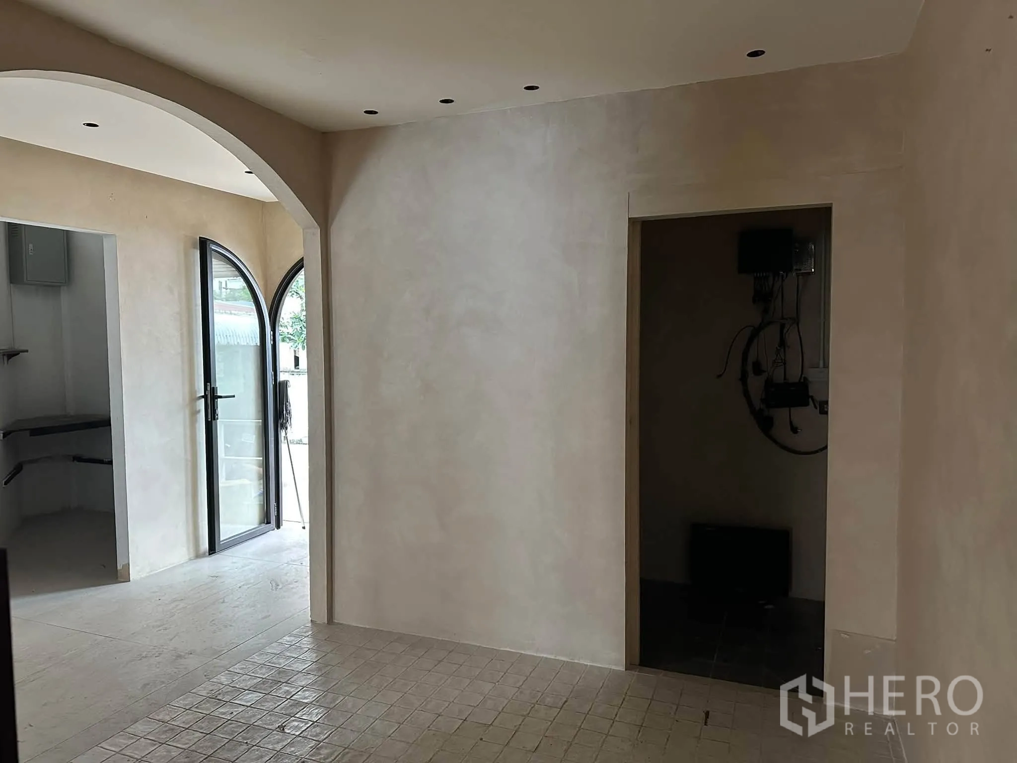 พื้นที่ขายของ for rent in Khlong Toei, Bangkok - โถงทางเดินซุ้มโค้ง ผนังโทนอ่อน เชื่อมไปยังห้องเล็กและประตูออก