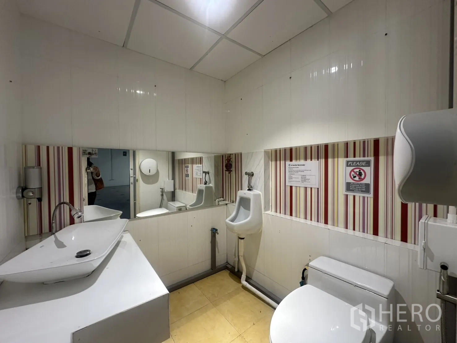 Retail Space for rent in Pathum Wan, Bangkok - Second restroom with a urinal, basin, and striped wall tiles.