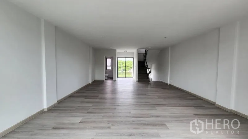 Home Office for rent - Deep rectangular room leading to a balcony with a staircase on the right.
