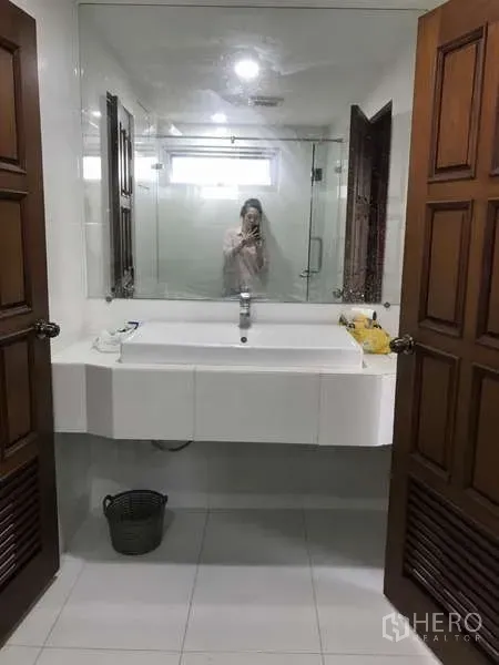 公寓 出售在Watthana, Bangkok - 盥洗区，超大镜面、下嵌式洗手盆与木质双开门。