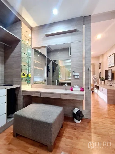 Detached House for rent in Sai Mai, Bangkok - Modern dressing area with vanity, mirror wall, open shelving and an ottoman.