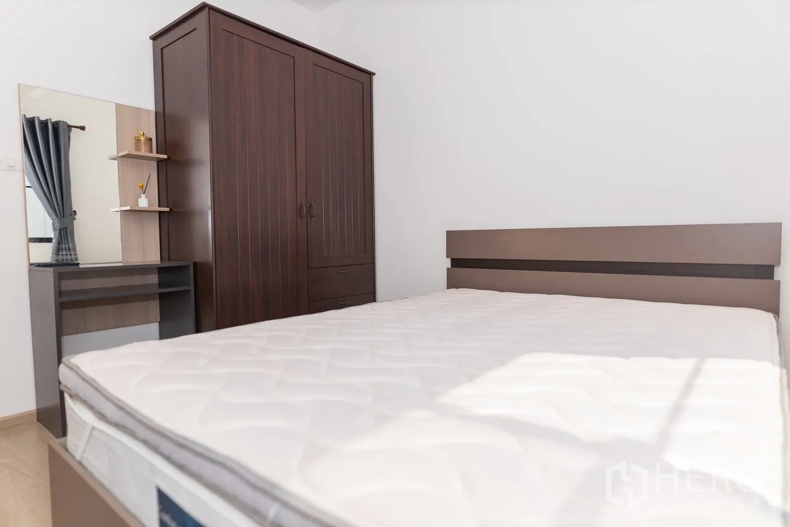 ทาวน์เฮาส์ for rent in Bang Phli, Samut Prakan - ห้องนอนพร้อมเตียงตู้เสื้อผ้าไม้สีเข้มและโต๊ะเครื่องแป้ง