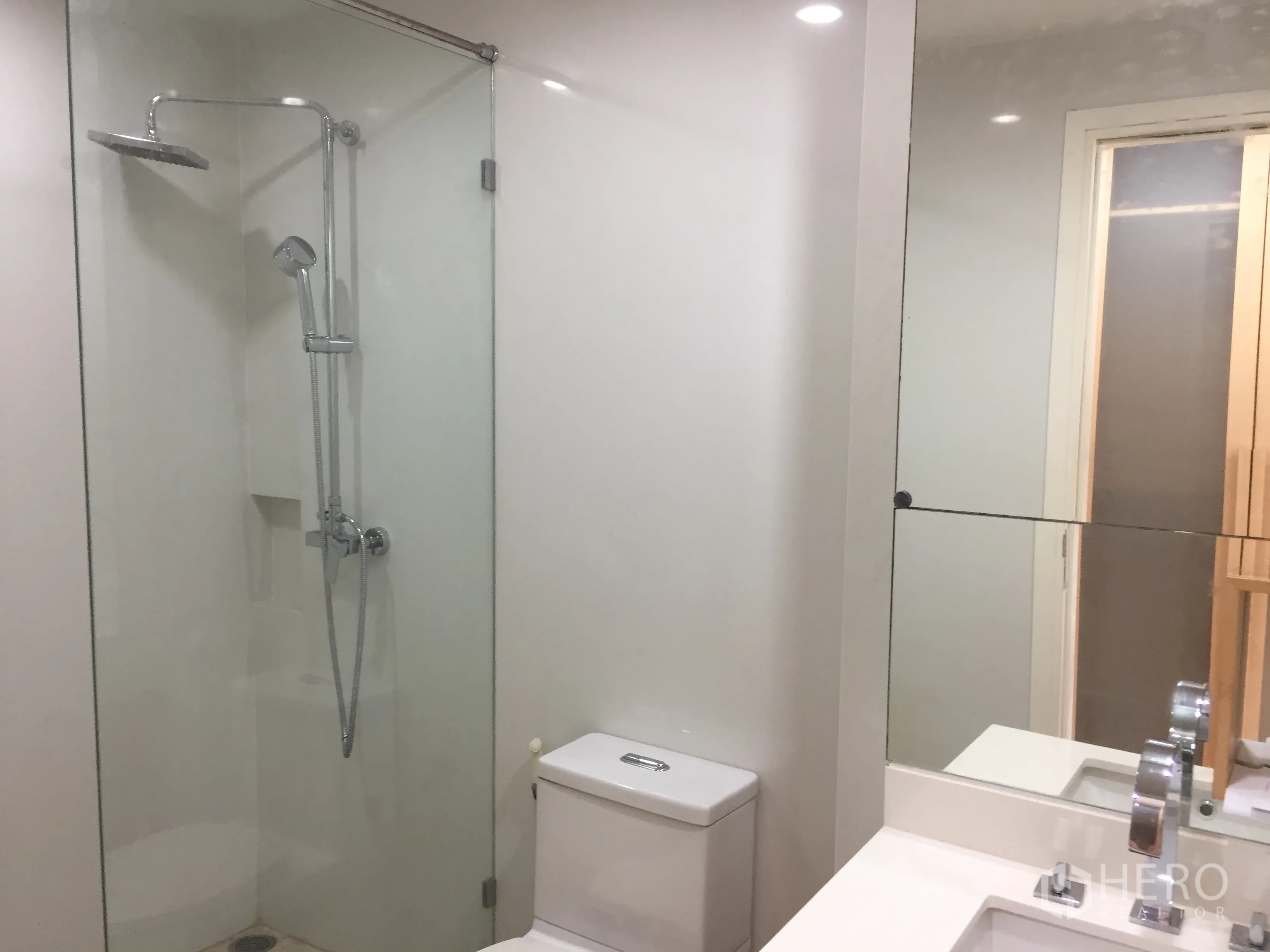 公寓 出租或出售在Watthana, Bangkok - 现代浴室，玻璃淋浴间配顶喷花洒与大镜台。