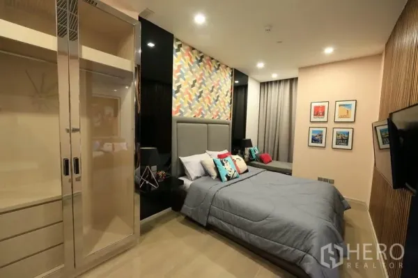公寓 出租或出售在Watthana, Bangkok - 卧室设软包床头、彩色背景墙与内置衣柜。