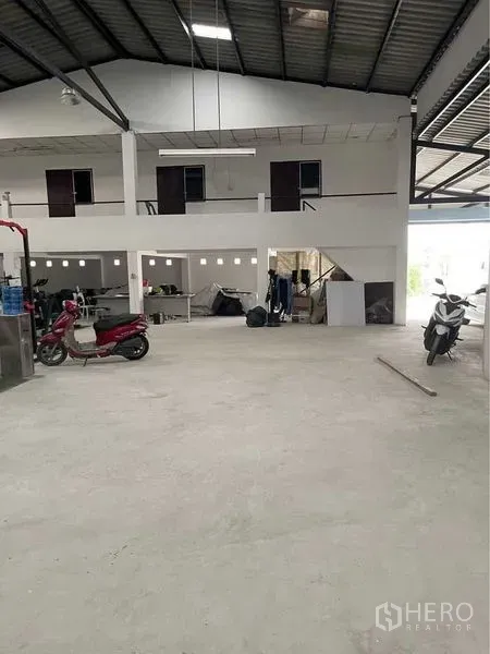 Warehouse for sale in Lam Luk Ka, Pathum Thani - Spacious warehouse interior with high ceiling, mezzanine offices and smooth concrete floor in Lam Luk Ka.