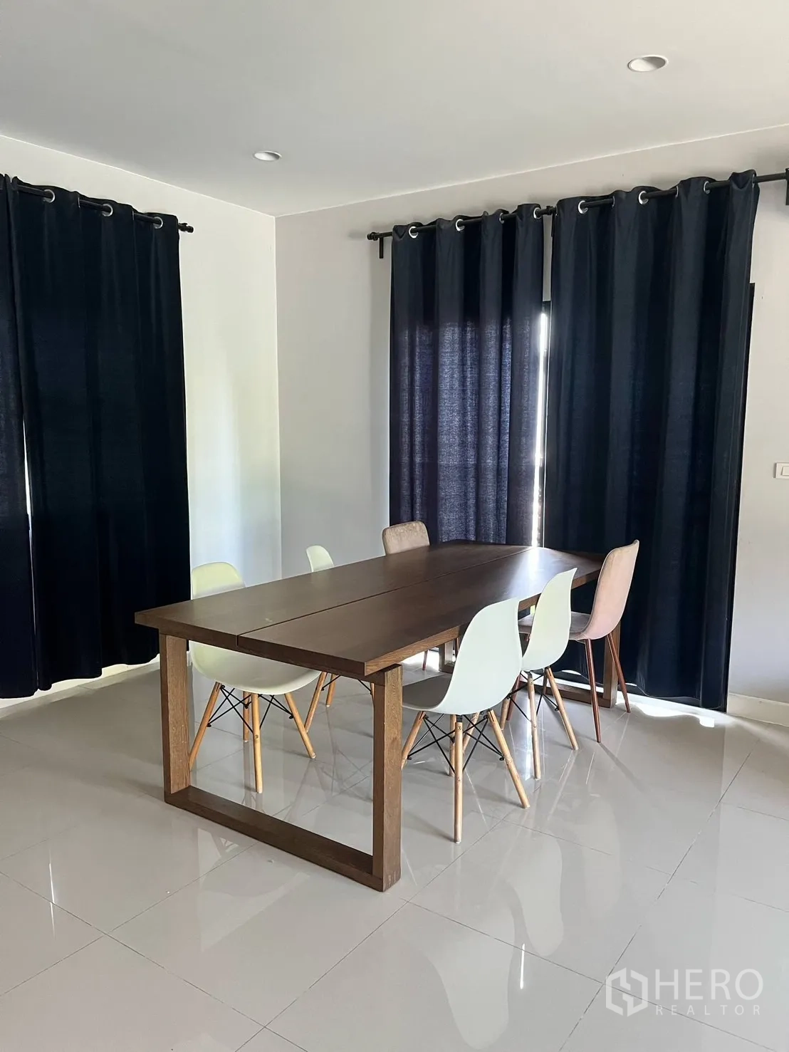 Detached House for rent or sale in Lam Luk Ka, Pathum Thani - Dining room with large wooden table and mix of modern chairs.