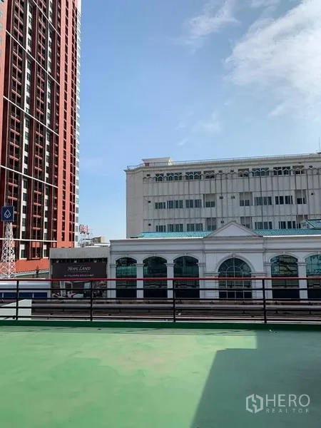Shophouse for rent in Khlong Toei, Bangkok - Rooftop terrace with city views across nearby buildings under a clear blue sky.