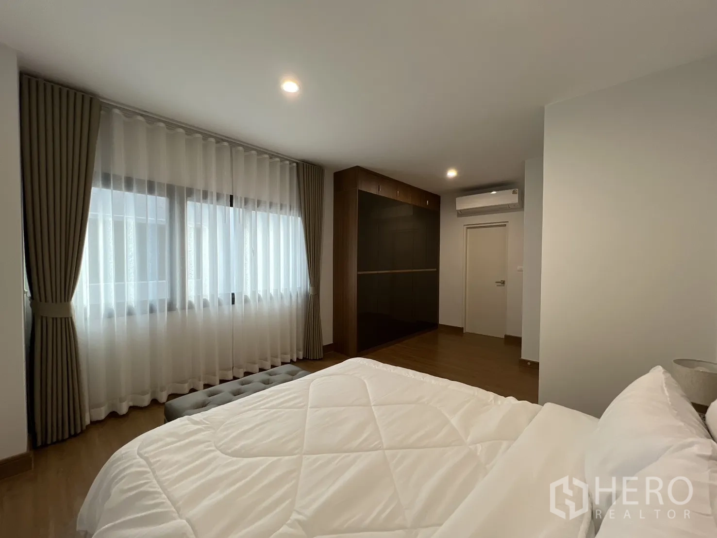 独立式住宅 出租在Prawet, Bangkok - 大卧室，整墙亮面衣柜与宽窗。