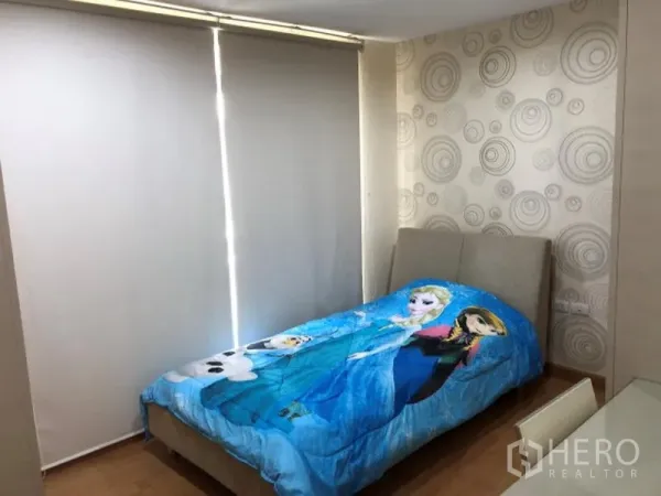 Condominium for rent in Khlong Toei, Bangkok - Cozy bedroom with patterned wallpaper, single bed, and roller blackout blinds.